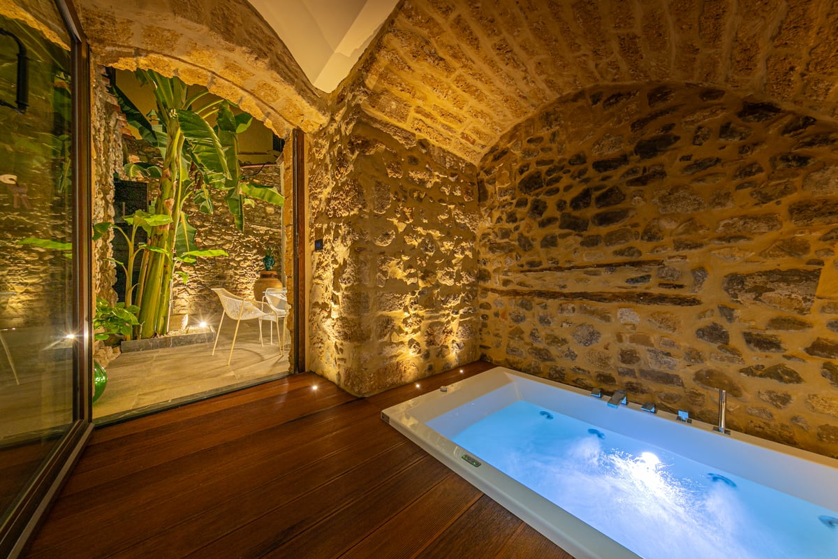 The whirlpool bath beside the opening onto the courtyard.