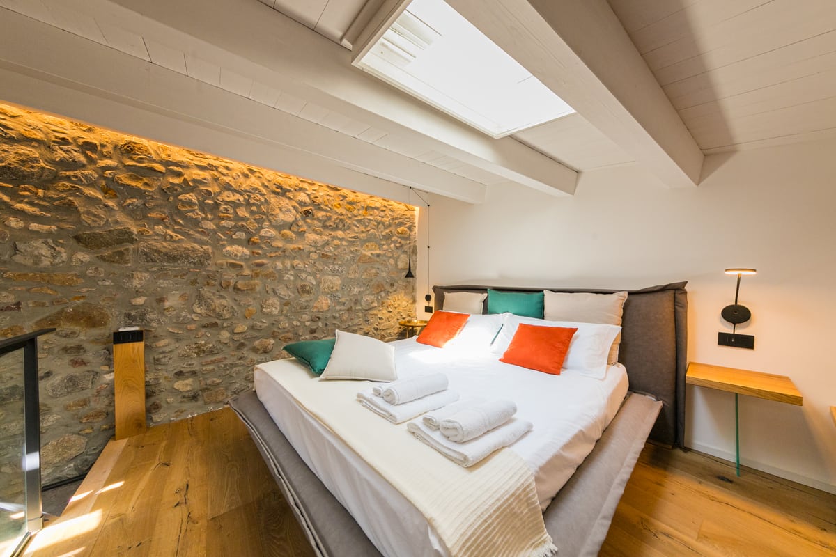 The double bed and illuminated stone wall.