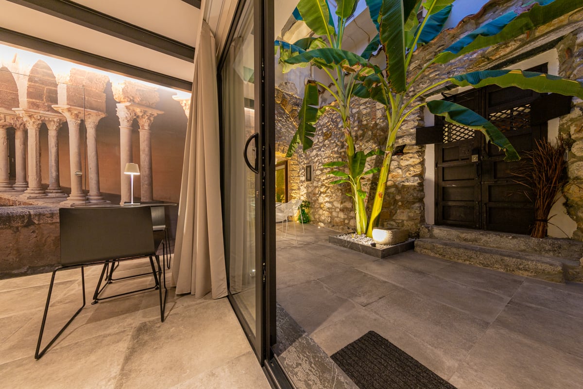 The banana plant and courtyard table in evening light, seen from the living area.
