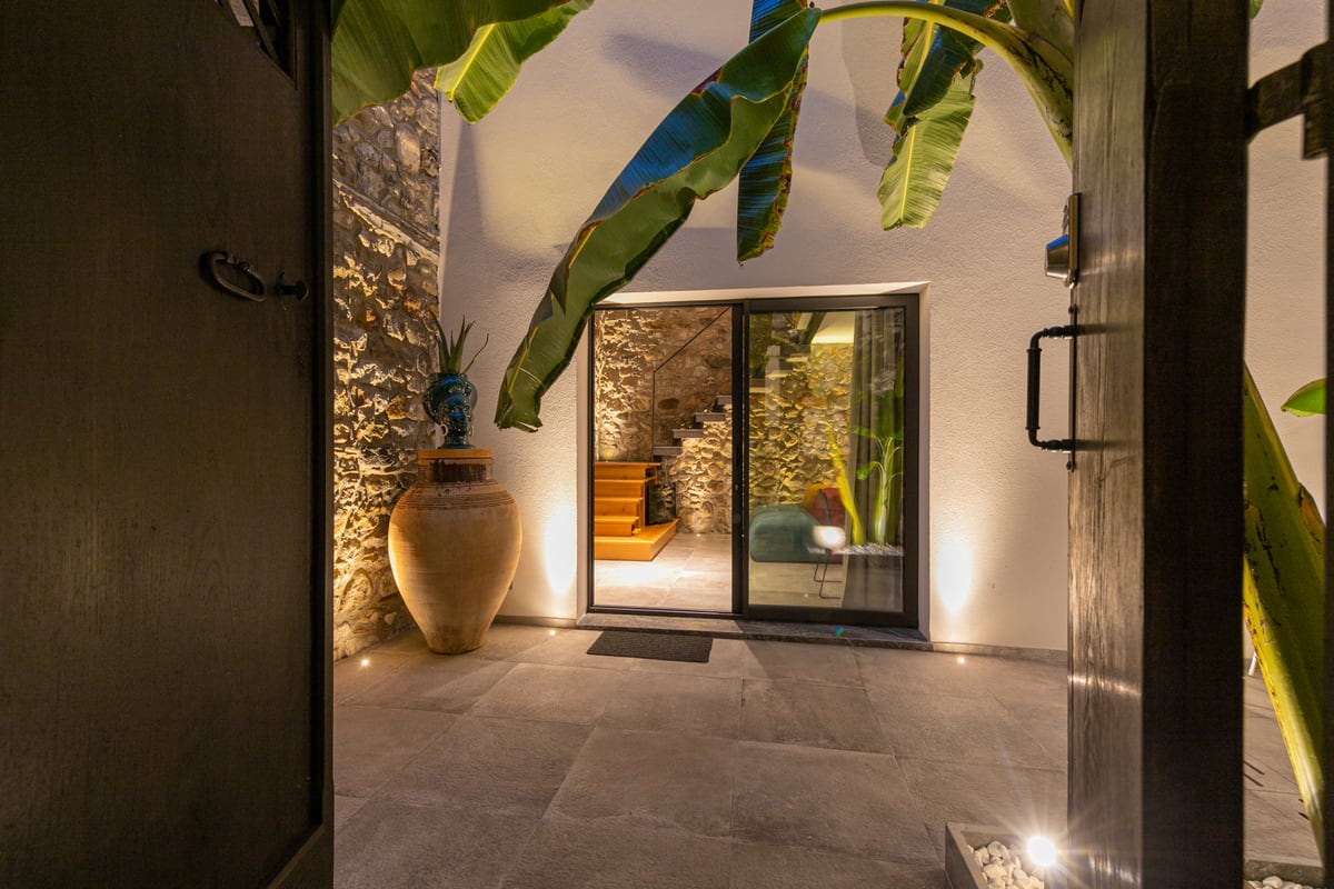 From the threshold, dark doors frame the courtyard and the glazed view of the staircase.